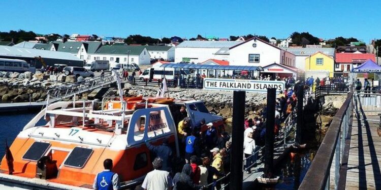 Pasajeros descendiendo en le muelle de Stanley de lanchas que los transportan desde los cruceros a tierra