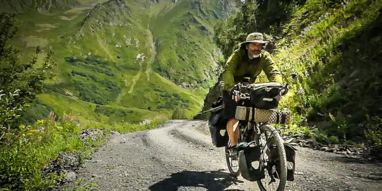 Viajando en bicicleta por un camino de ripio entre montañas