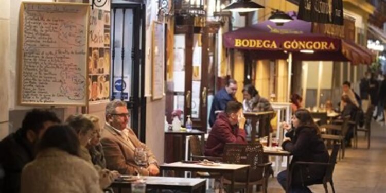 Varias personas en la terraza de un bar.