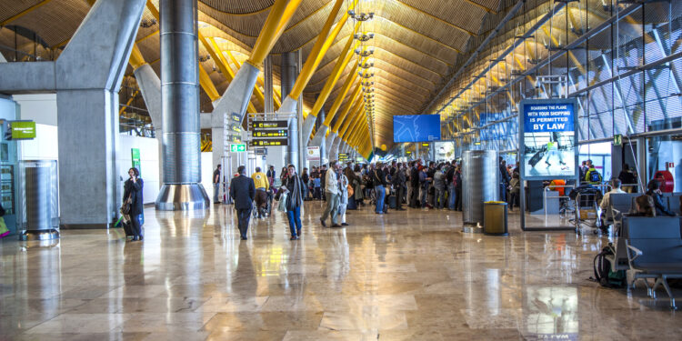MADRID - APRIL 1: Passengers walk by at the new terminal T4 at Barajas airport on April 1,2012 in Madrid. This addition opened 2006 makes Madrid the 2. largest airport in the world.