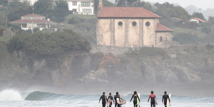 Un grupo de surferos se aproxima a la playa de Mundaka.