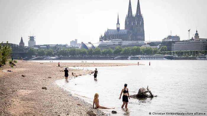 Bañistas se refrescan en el Rin con la catedral de Colonia de fondo.