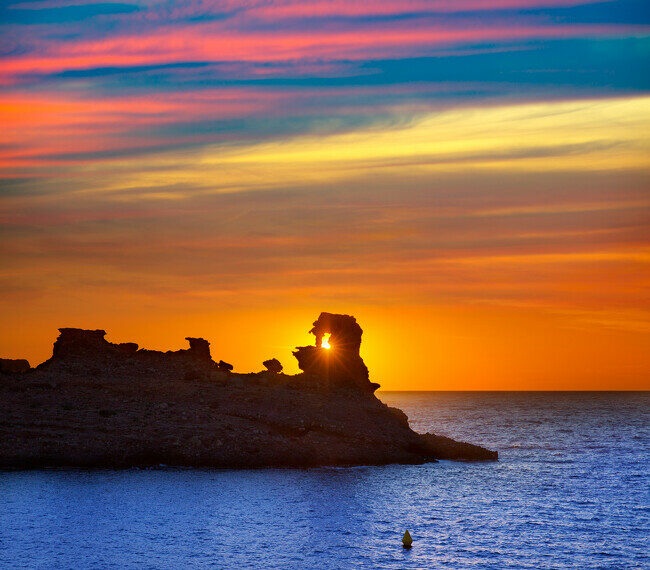 Tras la extraña formación en la punta de la roca se esconde el sol y Cala Morell es testigo de ellos