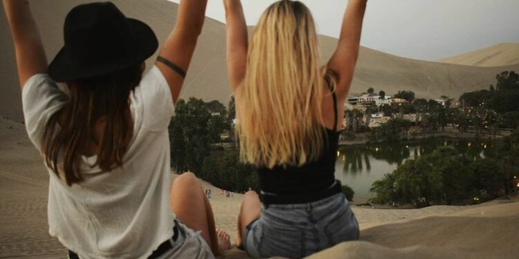 Mujeres que viajan solas haciendo amistad en un oasis en el desierto