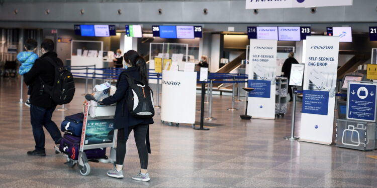 Los turistas caminan con su equipaje dentro de una tranquila Terminal 2 del aeropuerto de Helsinki-Vantaa en Vantaa, Finlandia, el 27 de abril de 2021 (Lehtikuva/Jussi Nukari via REUTERS)
