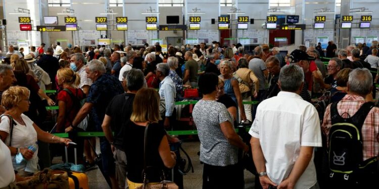 FOTO DE ARCHIVO: Viajeros haciendo fila frente a los mostradores de facturación del aeropuerto de Málaga-Costa del Sol en Málaga, Andalucía, España, el 4 de junio de 2022. REUTERS/Jon Nazca
