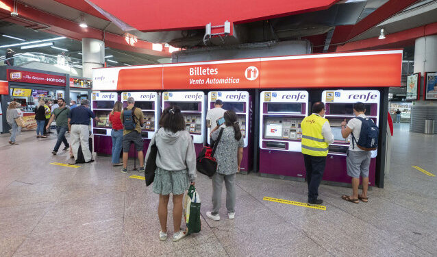 Archivo - Varias personas adquieren sus billetes en las taquillas de venta automática de la estación de tren de Atocha