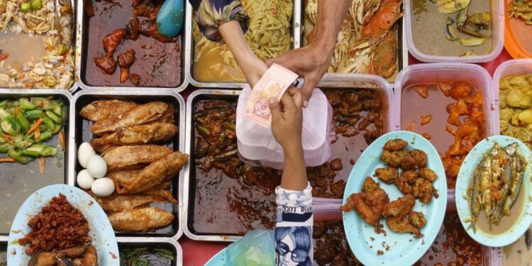 Pagando por comida en puesto callejero asiático