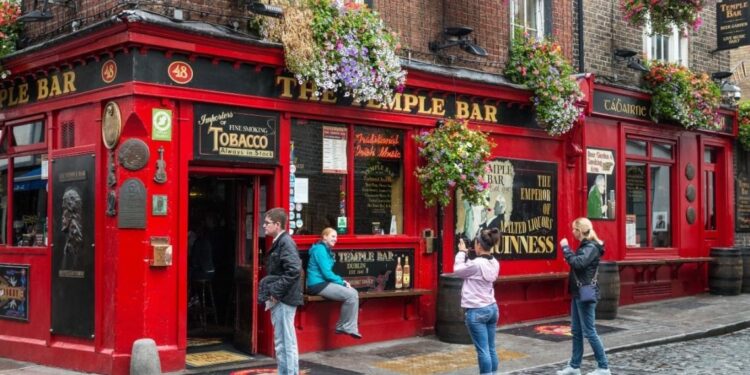 Turistas sacándose fotos frente al famoso The Temple Bar, en Dublín, Irlanda