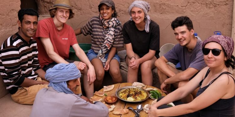 Grupo de jóvenes comiendo con locales en país árabe