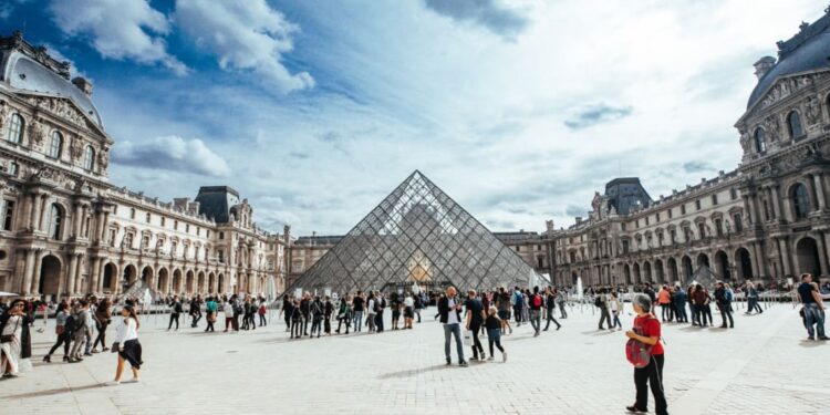 Turistas alrededor del Museo del Louvre en París, Francia