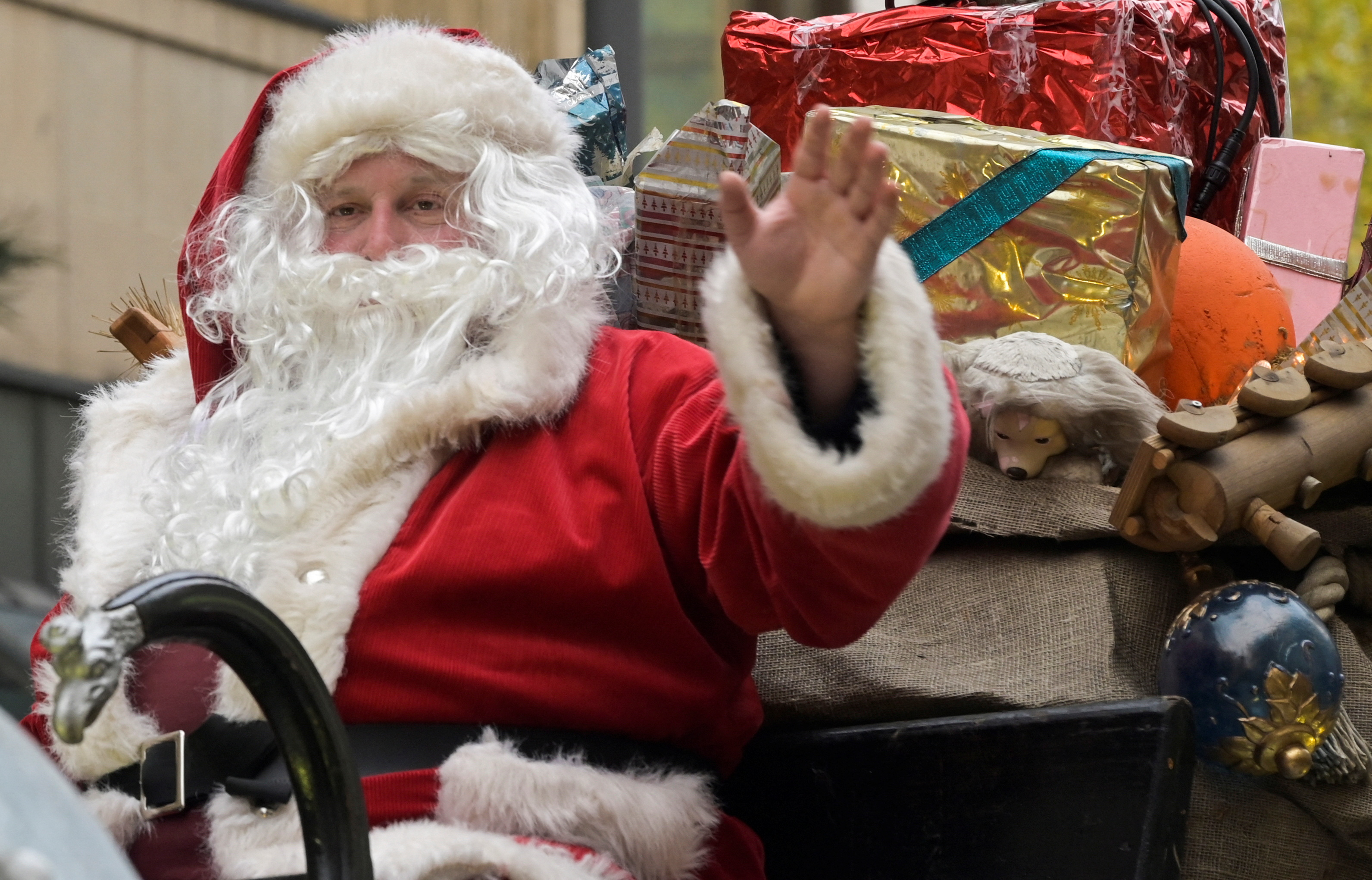 An actor, dressed as Santa Claus waves to Christmas shoppers during a parade in a busy shopping street, on the second weekend of advent, in Hamburg, Germany December 3, 2022. REUTERS/Fabian Bimmer