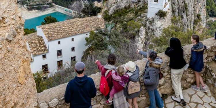 Un grupo de turistas contemplando el casco antiguo de Castell de Guadalest.