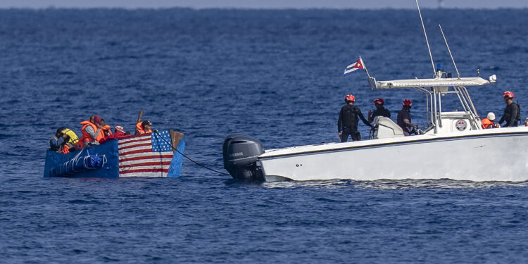 Personas a bordo de una balsa con una bandera estadounidense pintada a un costado son detenidas por la Guardia Costera de Cuba, el lunes 12 de diciembre de 2022, frente a La Habana. (AP Foto/Ramon Espinosa)