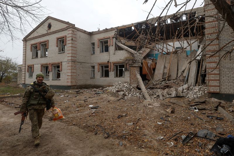 Un militar ucraniano pasa por delante de un edificio dañado durante un ataque con misiles rusos en el pueblo de Novooleksandrivka, en la región de Kherson, Ucrania