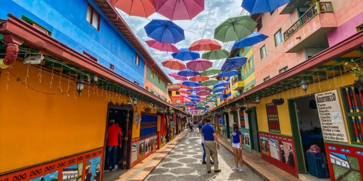 Calle peatonal con paraguas de colores colgados en Guatapé, uno de los mejores destinos para viajar solo en Colombia
