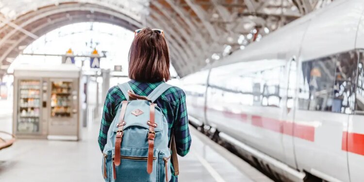 Joven en una estación de tren a punto de viajar