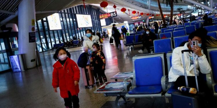FOTO DE ARCHIVO. Un niño camina mientras la gente espera con sus maletas en una estación de tren, en medio del brote de la enfermedad por coronavirus (COVID-19), en Wuhan, provincia de Hubei, China. 1 de enero de 2023. REUTERS/Tingshu Wang
