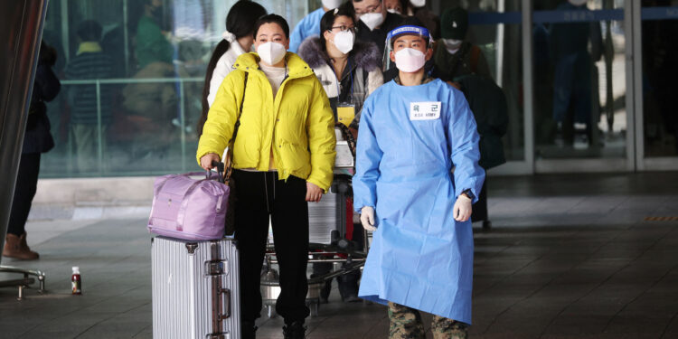 Un soldado surcoreano guía a un grupo de turistas chinos que arriban al aeropuerto de Incheon (Reuters)