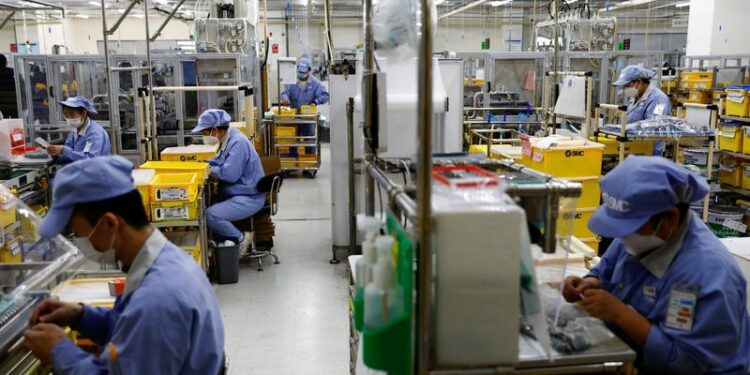 FOTO DE ARCHIVO. Empleados trabajan en una fábrica de SMC Corporation, durante una visita organizada para los medios de comunicación, en medio del brote de la enfermedad por coronavirus (COVID-19) en Pekín, China. 10 de enero de 2023. REUTERS/Tingshu Wang