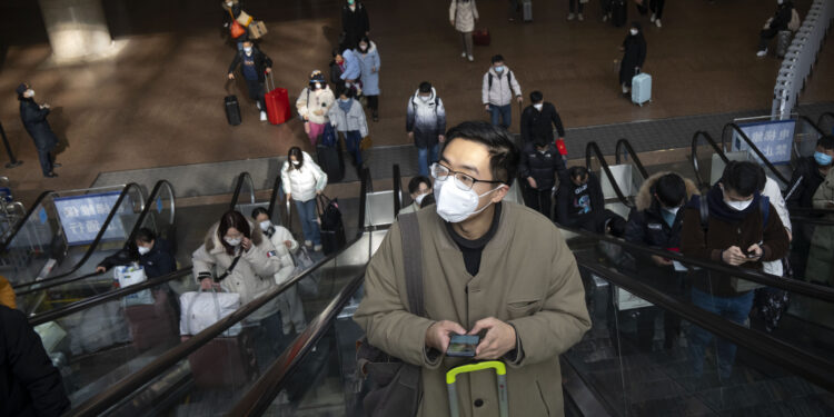 Viajeros en escaleras mecánicas en la Estación de Ferrocarril del Oeste de Beijing, el miércoles 18 de enero de 2023. (AP Foto/Mark Schiefelbein)