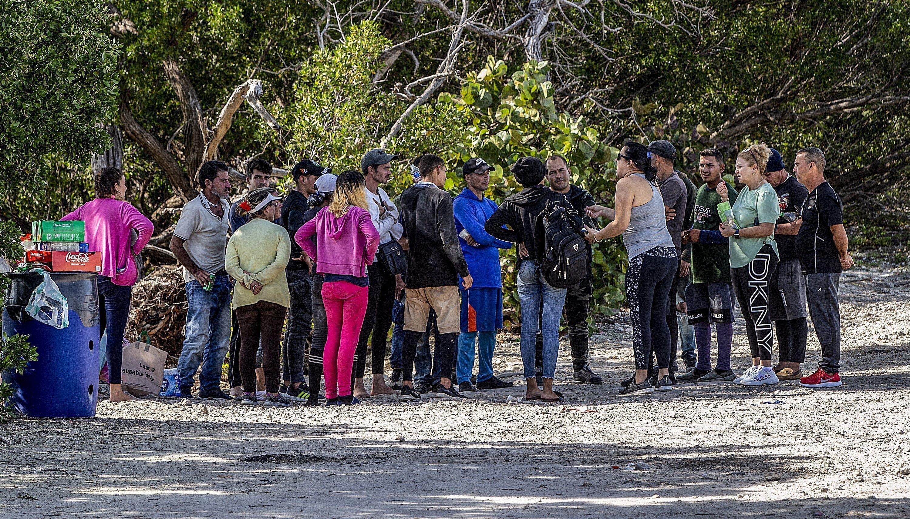 Un grupo de migrantes cubanos se reúne cerca de un camino en la isla Duck Key el lunes 2 de enero de 2023, en los cayos de Florida. (Pedro Portal/Miami Herald vía AP)