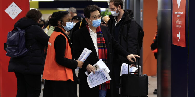 Pasajeros procedentes de China aguardan frente a una zona de pruebas de COVID-19 en el aeropuerto Roissy Charles de Gaulle, al norte de París, el domingo 1 de enero de 2023. (AP Foto/Aurelien Morissard)