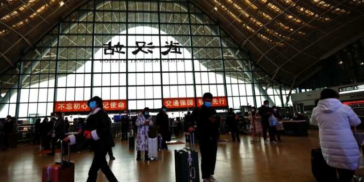 FOTO DE ARCHIVO: Personas esperan con maletas en una estación de tren, en medio del brote de la enfermedad por coronavirus (COVID-19), en Wuhan, provincia de Hubei, China 1 de enero de 2023. REUTERS/Tingshu Wang/