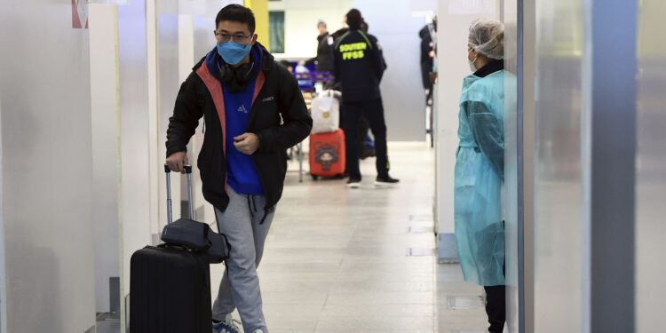 Un pasajero procedente de China camina luego de someterse a una prueba de COVID-19 en el aeropuerto Roissy Charles de Gaulle, al norte de París, el domingo 1 de enero de 2023. (AP Foto/Aurelien Morissard)