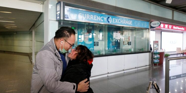FOTO DE ARCHIVO. Varias personas se abrazan en la puerta de llegadas internacionales del Aeropuerto Internacional de Pekín Capital después de que China levantara el requisito de cuarentena por la enfermedad del coronavirus (COVID-19) para los viajeros entrantes en Pekín, China. 8 de enero de 2023. REUTERS/Thomas Peter