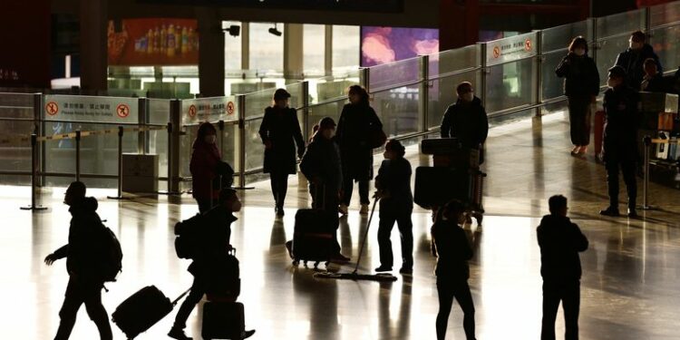 Viajeros entran en una terminal, durante el ajetreo anual de viajes de la Fiesta de la Primavera antes del Año Nuevo Lunar chino, mientras continúa el brote de la enfermedad por coronavirus (COVID-19), en el Aeropuerto Internacional de Pekín Capital, Pekín, China. 18 de enero de 2023. REUTERS/Tingshu Wang