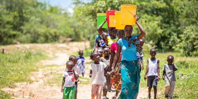 Mujeres y niños recolectan agua de un punto de pozo recientemente restaurado en el valle de Gwembe, Zambia. (archivo)
