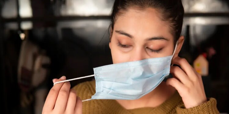 Chica quitándose la mascarilla