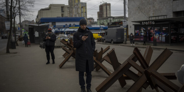 Gente esperando a que llegue un autobús en Kiev, Ucrania, el lunes 30 de enero de 2023. (AP Foto/Daniel Cole)