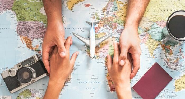 pareja de la mano sobre mapa del mundo