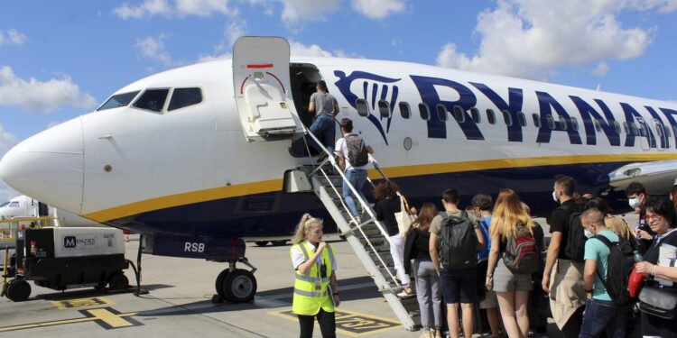 Un grupo de turistas se prepara para montarse en un avión de la compañía de bajo coste Ryanair