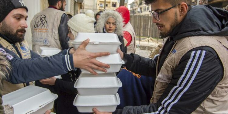 Las personas afectadas por el terremoto en Alepo, Siria, reciben comidas calientes distribuidas por el Programa Mundial de Alimentos.