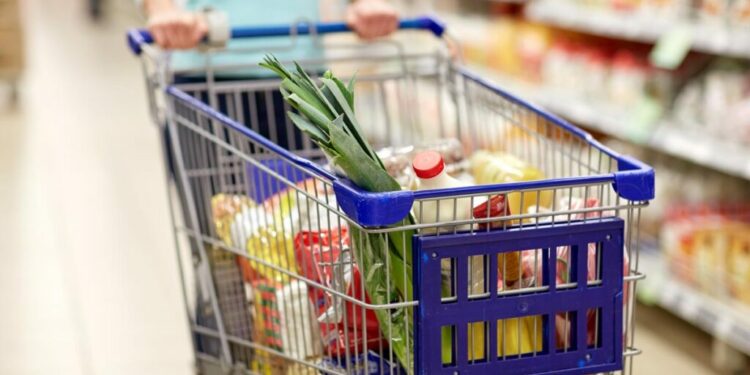 Close up of various foods in a shopping cart.