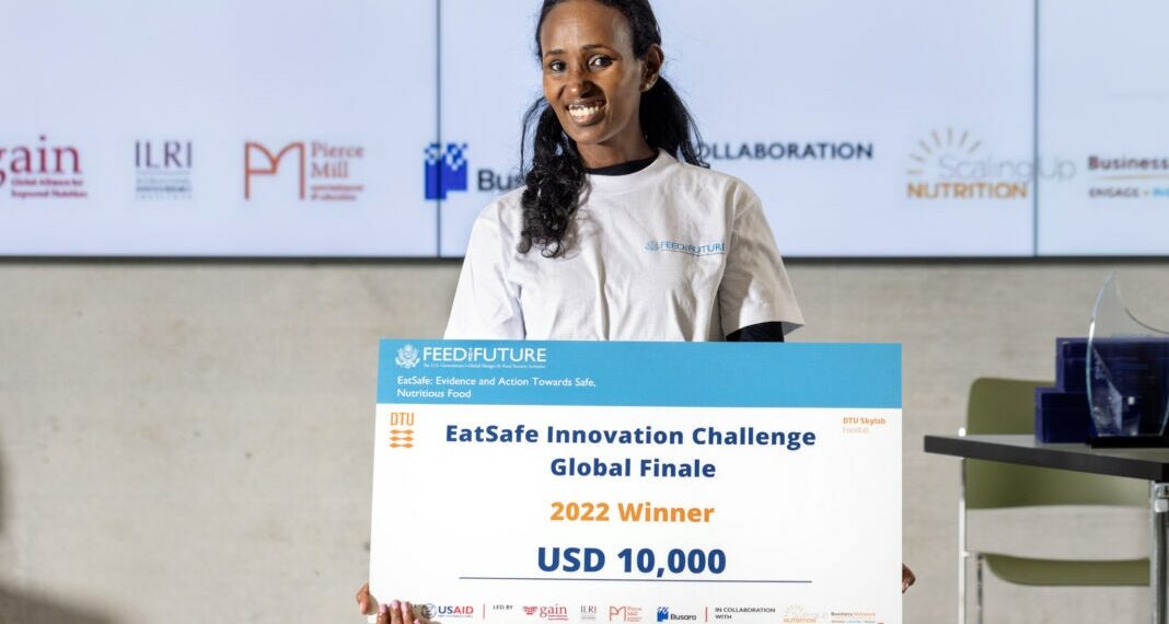 Helen Weldemichael sostiene un gran cheque por valor de 10.000 dólares y posa para una fotografía (Foto cedida por EatSafe/Universidad Técnica de Dinamarca)
