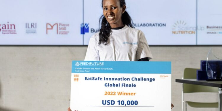 Helen Weldemichael sostiene un gran cheque por valor de 10.000 dólares y posa para una fotografía (Foto cedida por EatSafe/Universidad Técnica de Dinamarca)