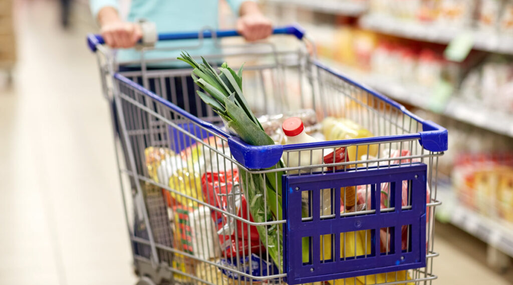 Close up of a shopping cart filled with groceries, representing Food Allergy Awareness Month.