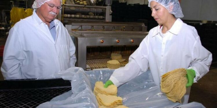 En esta foto de 2011, el cofundador de Ruiz Foods, Fred Ruiz, habla con la trabajadora Martha Arévalo en la planta de Dinuba. Aunque la empresa consolidará su sede corporativa en Texas, las plantas de fabricación de Dinuba y Tulare permanecerán.