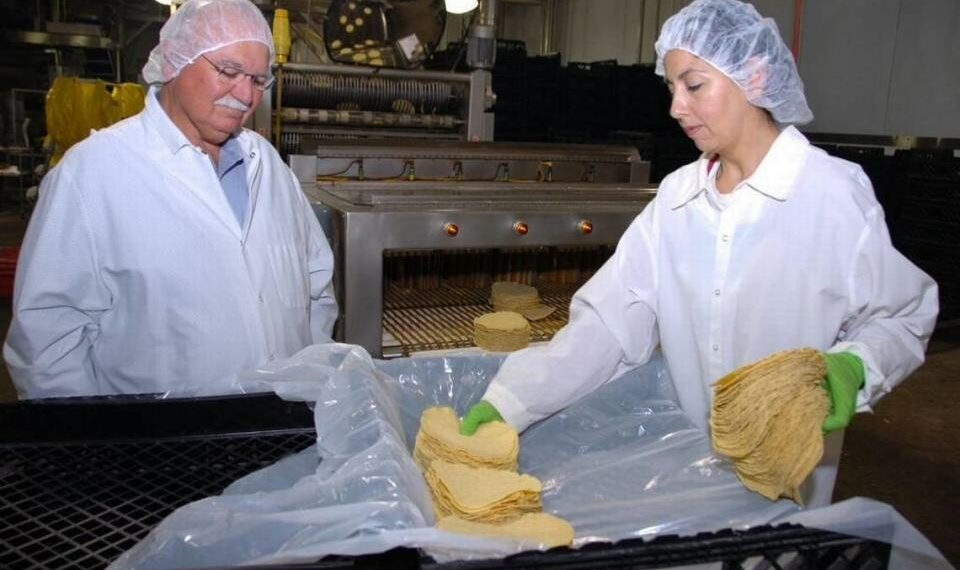 En esta foto de 2011, el cofundador de Ruiz Foods, Fred Ruiz, habla con la trabajadora Martha Arévalo en la planta de Dinuba. Aunque la empresa consolidará su sede corporativa en Texas, las plantas de fabricación de Dinuba y Tulare permanecerán.