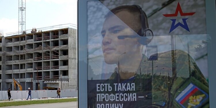Una valla publicitaria en apoyo de las fuerzas armadas rusas con el retrato de un soldado.