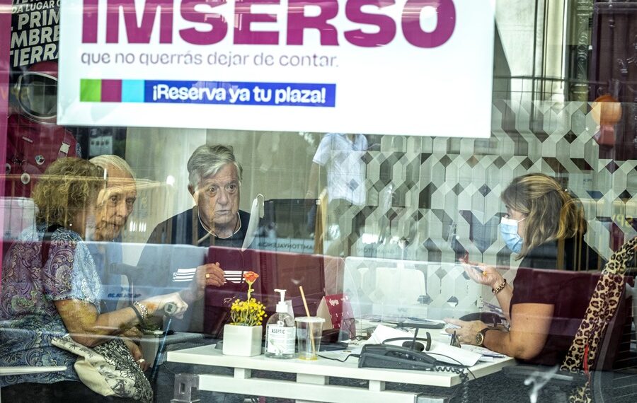 Varias personas mayores piden información en una agencia de viajes adherida al programa del Imserso