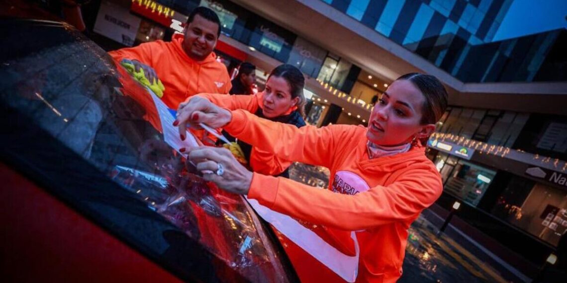 Mariana Rodríguez inicia su precampaña pegando calcomanías en el crucero donde empezó a promoverse Samuel García para gobernador