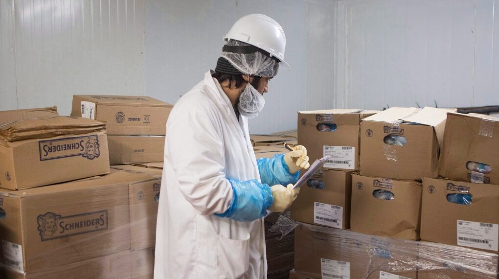 Imam Wahid Wardak, an inspector with the Halal Monitoring Authority, checks for HMA labels on boxes of chicken meat at a Halal meat wholesalers and distributors in Toronto on Thursday, April 6, 2017.THE CANADIAN PRESS/Chris Young