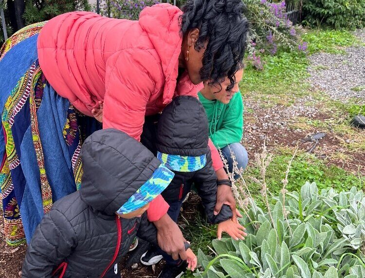 Lorna Parks, owner of House of Joy Childcare in Detroit, takes two of her children to visit the Keep Growing Detroit Garden.