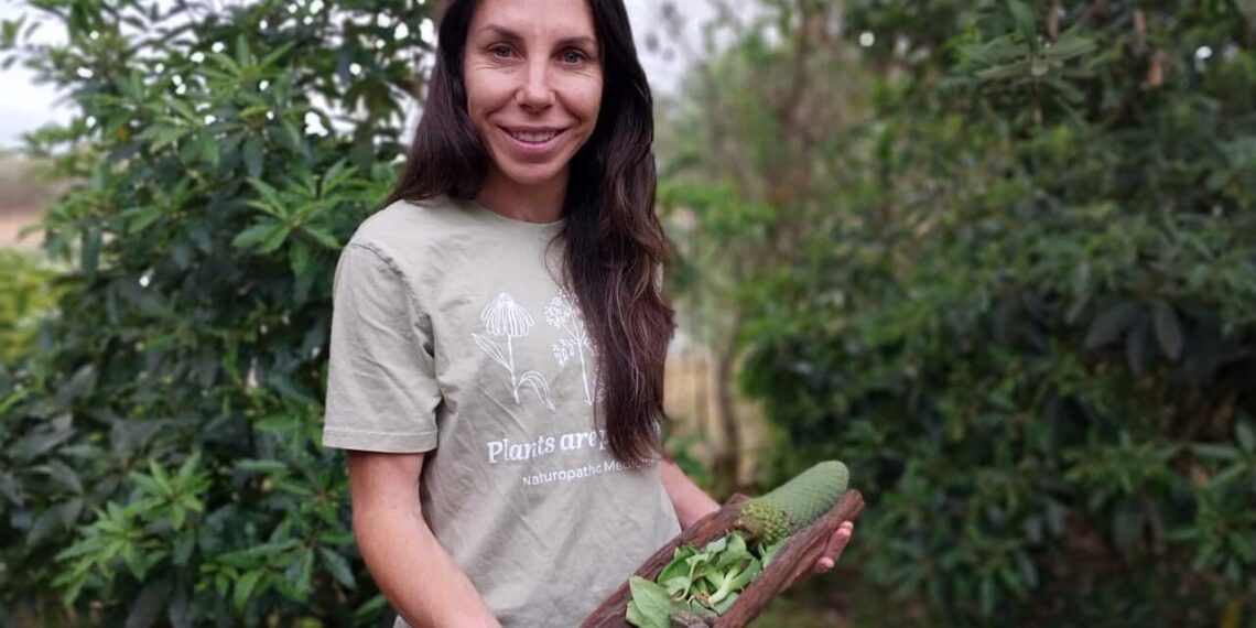 Felicity Kerslake with bush foods and medicine plants in her coolamon.