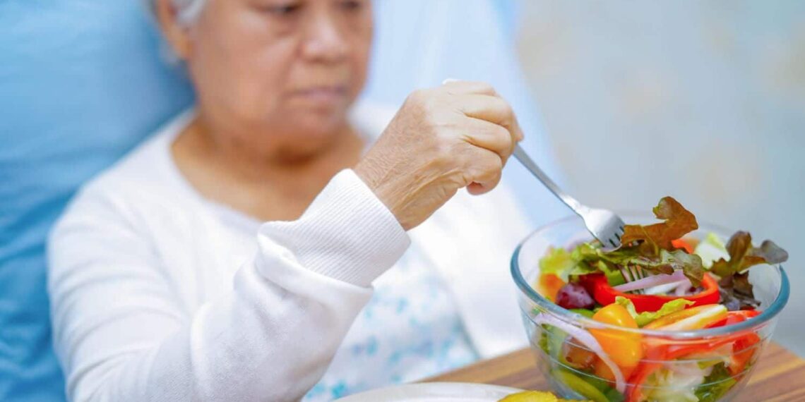 senior woman patient eating breakfast on bed in hospital.